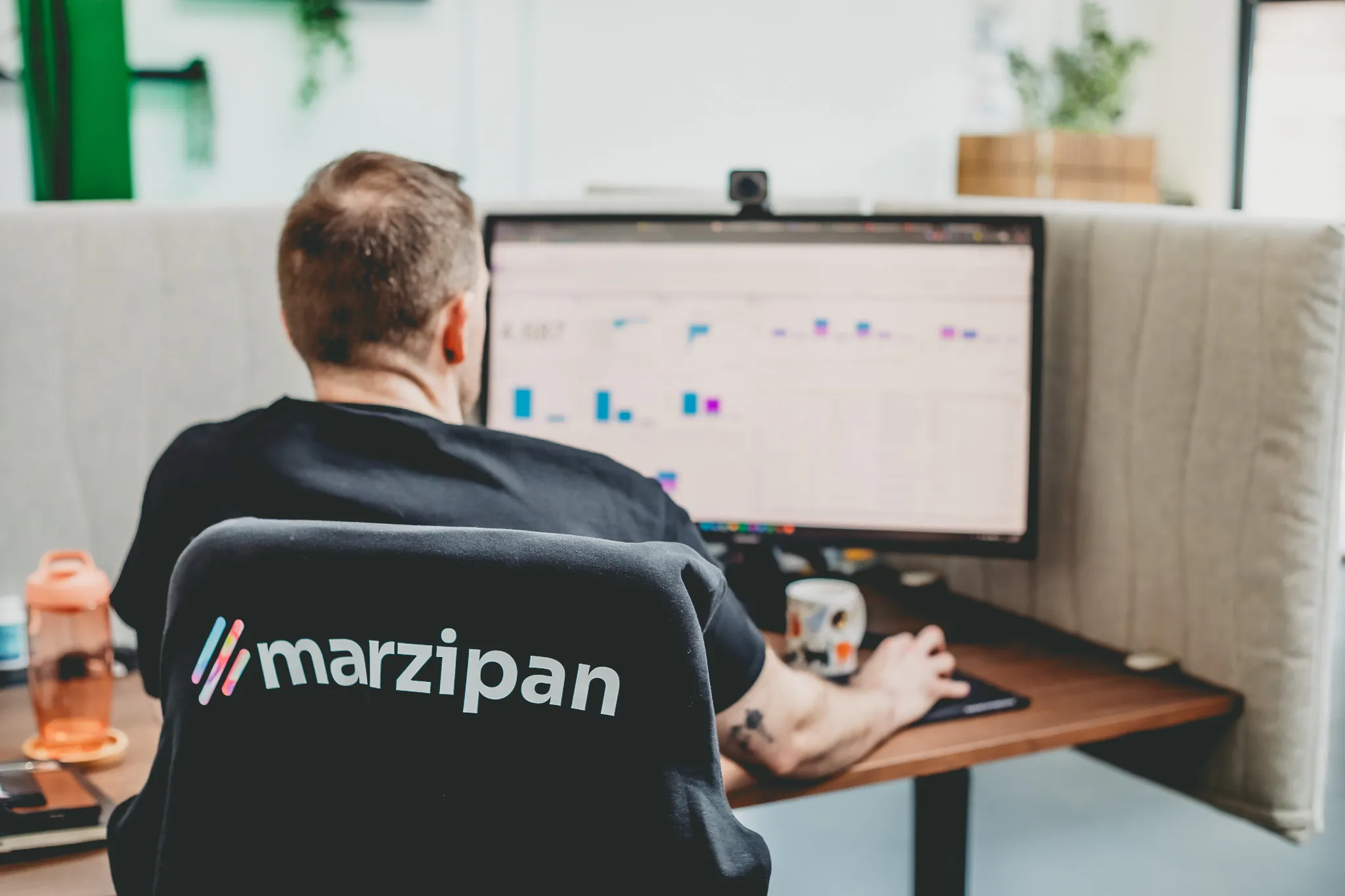 A Marzipan team member reviewing campaign performance dashboards at a desk in the studio