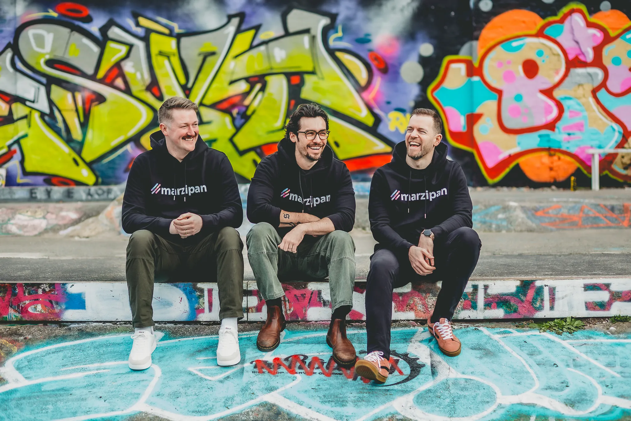 The Marzipan founding team in branded hoodies, brand identity applied consistently across every touchpoint